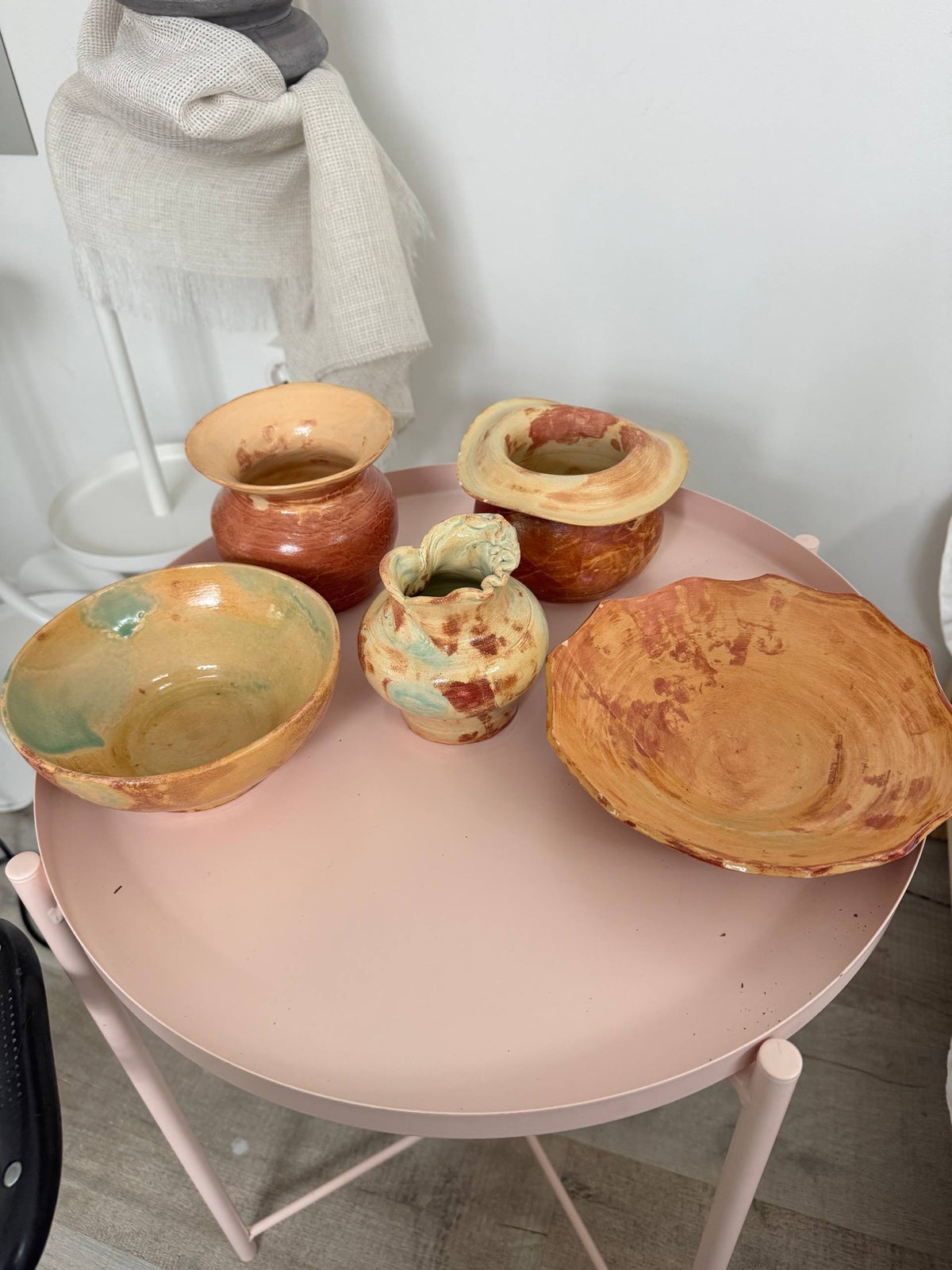 Glazed bowls and vases on a pink table in Maria's studio