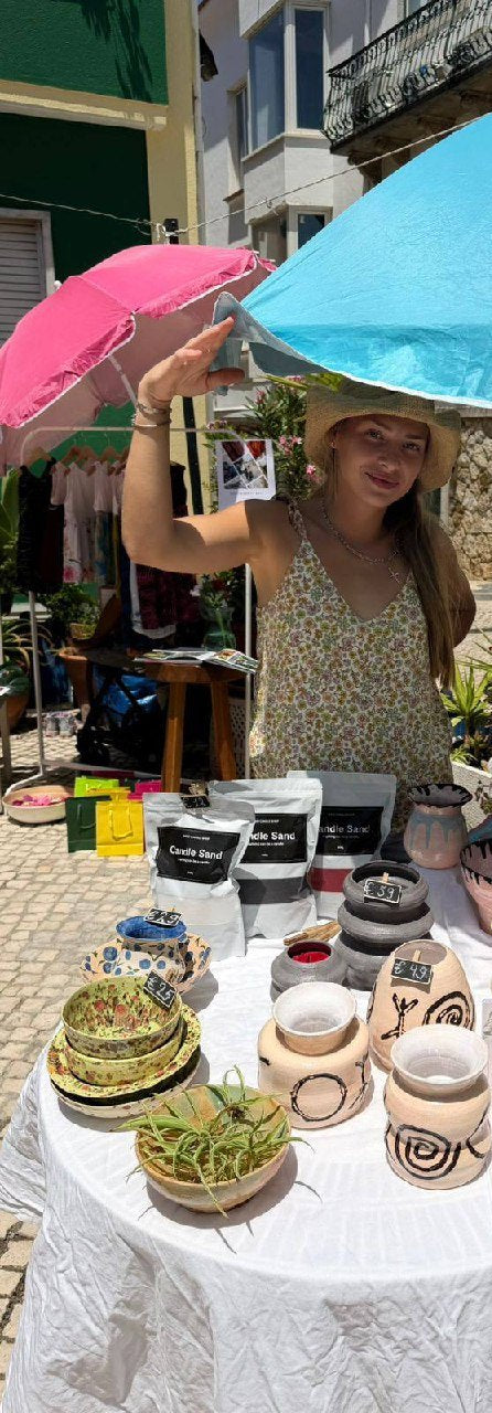 Maria at a market stall with her ceramics