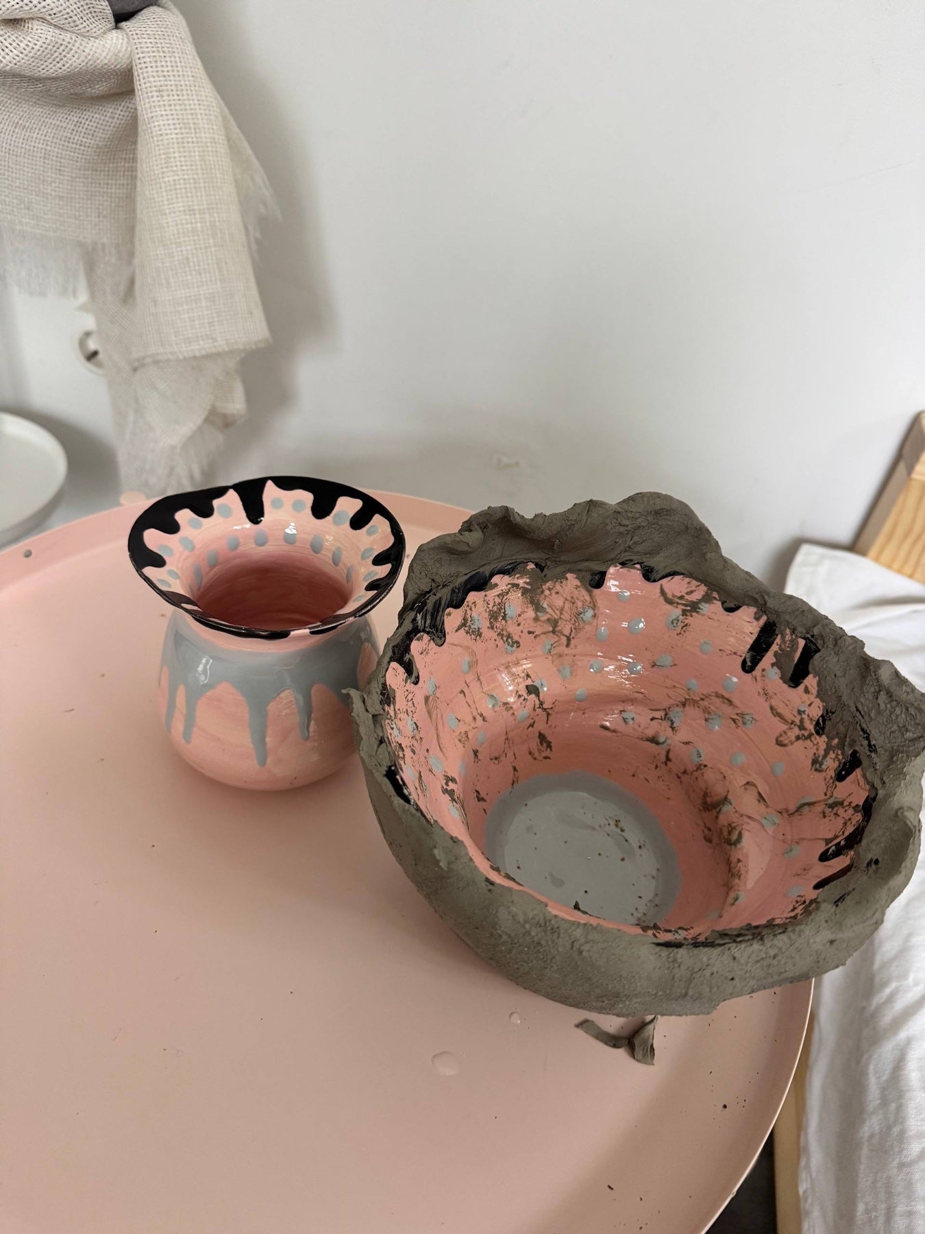 An experimental bowl with a raw clay rim beside a small painted vase